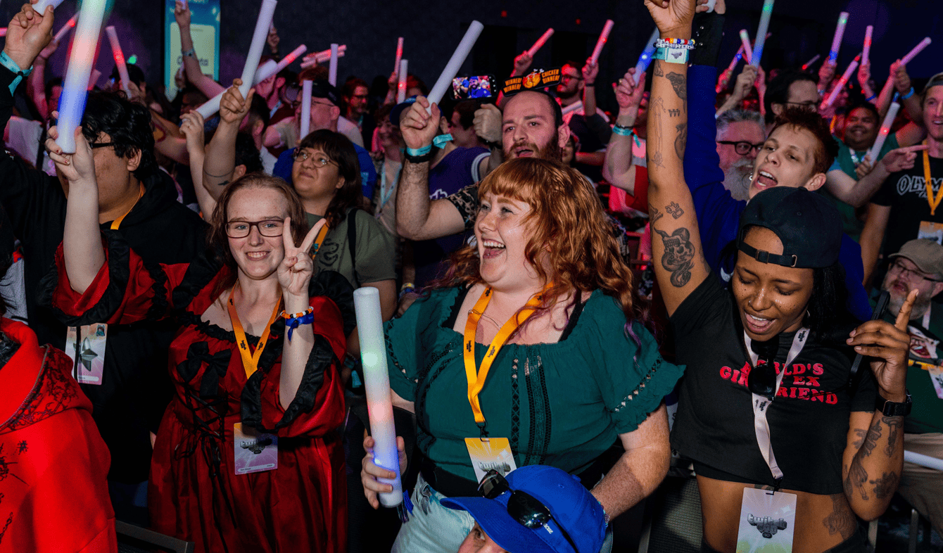 Fans cheering and waving glow sticks in a crowd